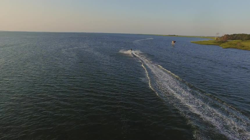 Person rides a jet ski on the coast