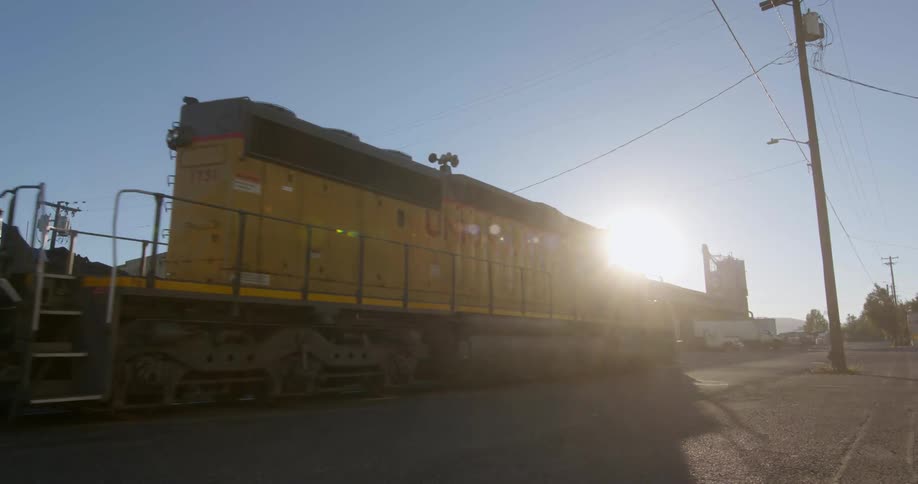 A train moves down the tracks on a sunny day