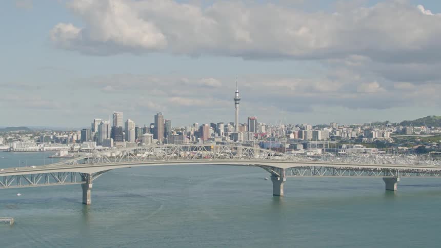 A bridge above a river leads to a large city
