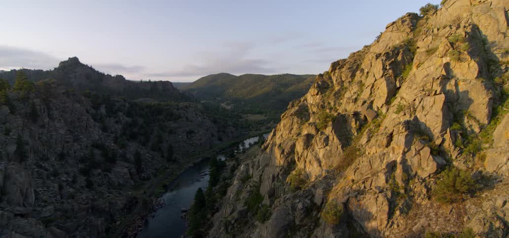 The sun shines on a valley between mountains