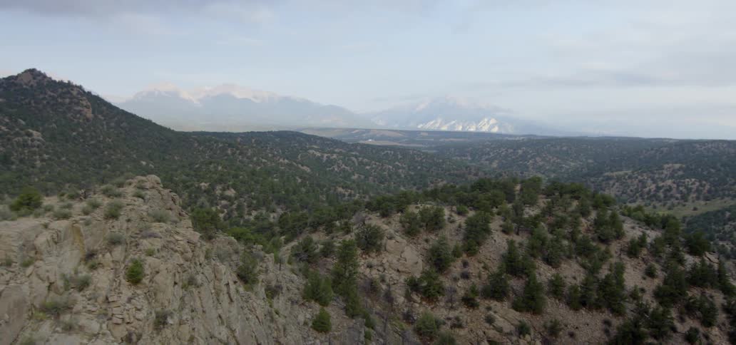 Shrubs and plants cover the stone mountains