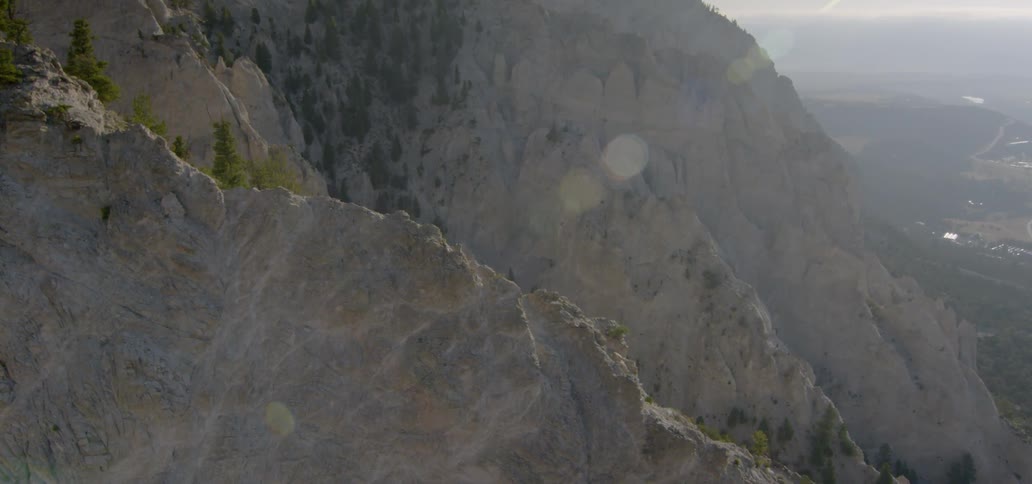 The sun shines on a tall stone mountain