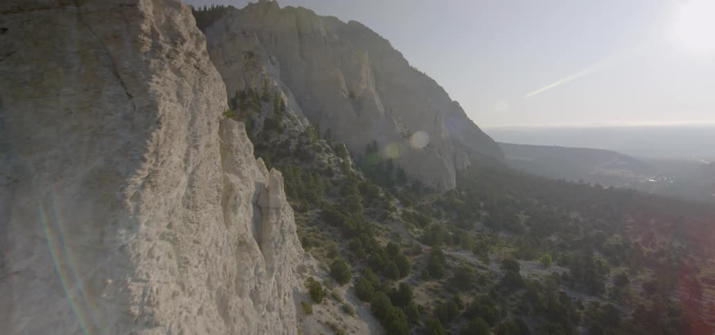 The sun shines on a valley between mountains