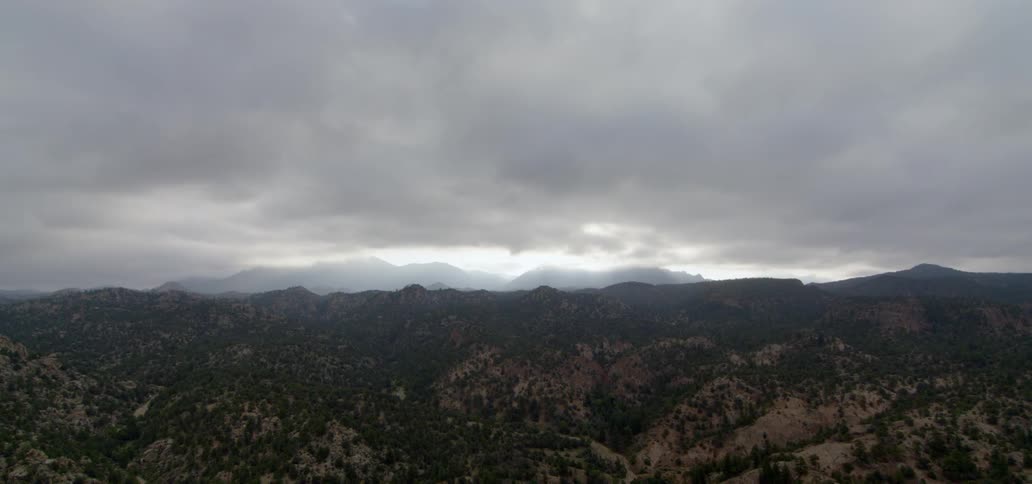 Low clouds are descending over a valley