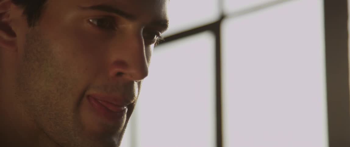 A man looks down and bites his lip