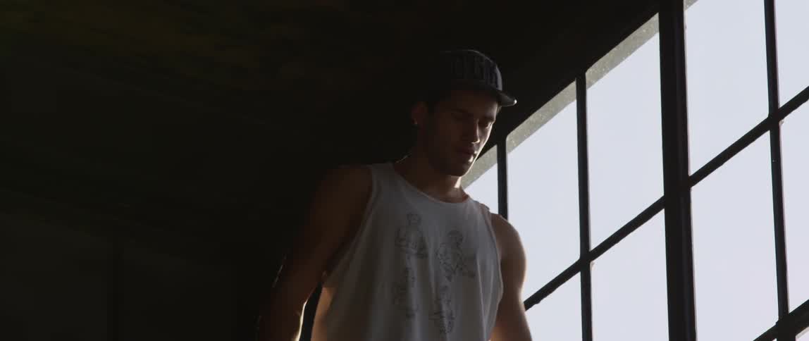 A young man approaches a window on a sunny day