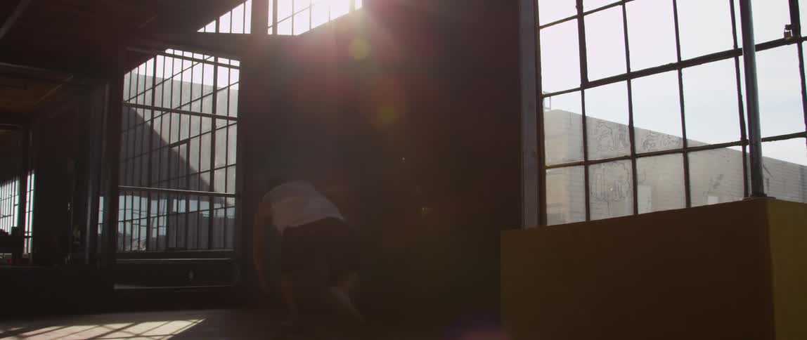 A man leaps and runs through indoor obstacles parkour style