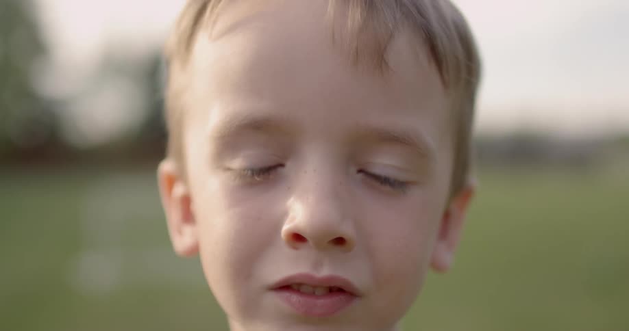 A little boy is looking into the camera lens