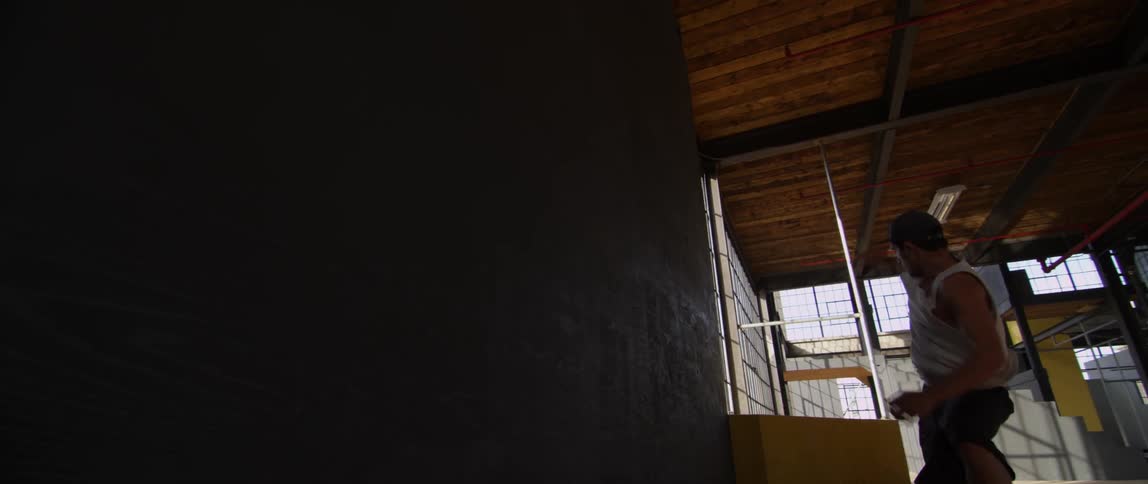 A man flips and jumps through an indoor obstacle course