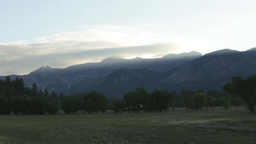 Time lapse of a grass field with mountains in the distance