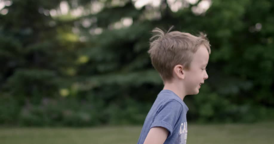 Boy runs outside near trees