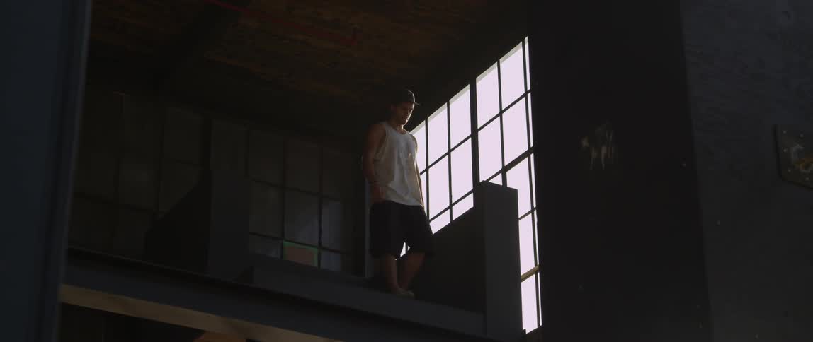 Man walking to a ledge in a warehouse