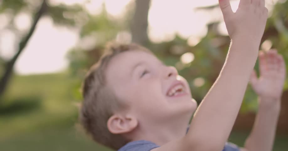 A young boy plays outside under the sun