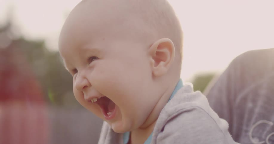 A baby is laughing and waving his arms