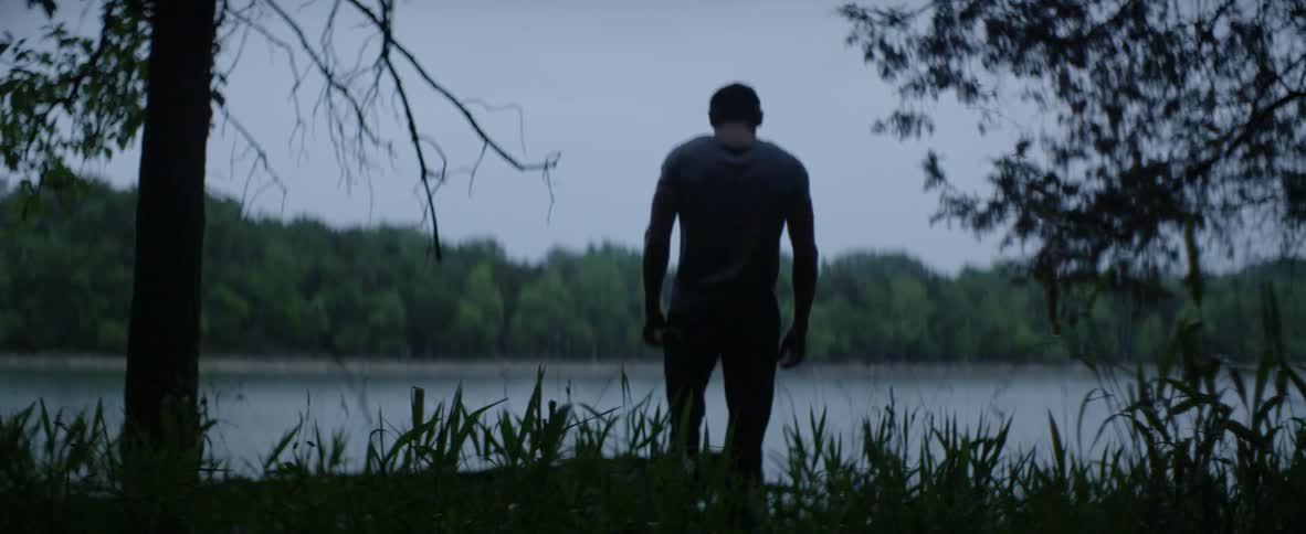 A man walks towards a lake