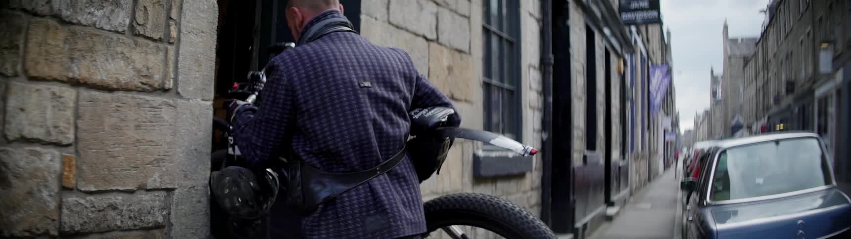 A person lifts a bike into a building
