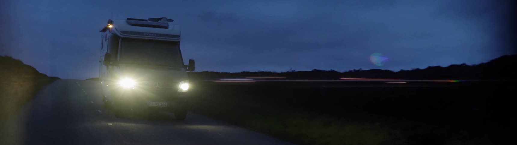 Van drives down a country road at night