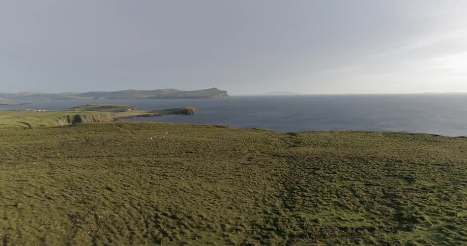 Grassy flat land next to a large body of water
