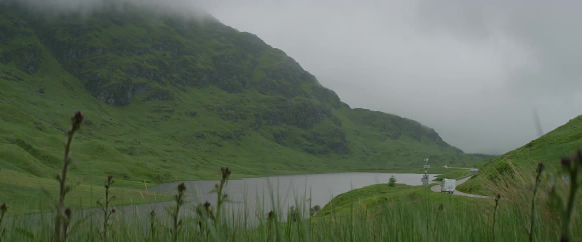 Mountains near a river and road on a cloudy day