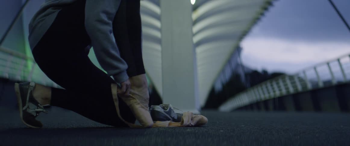 A woman puts on ballet shoes