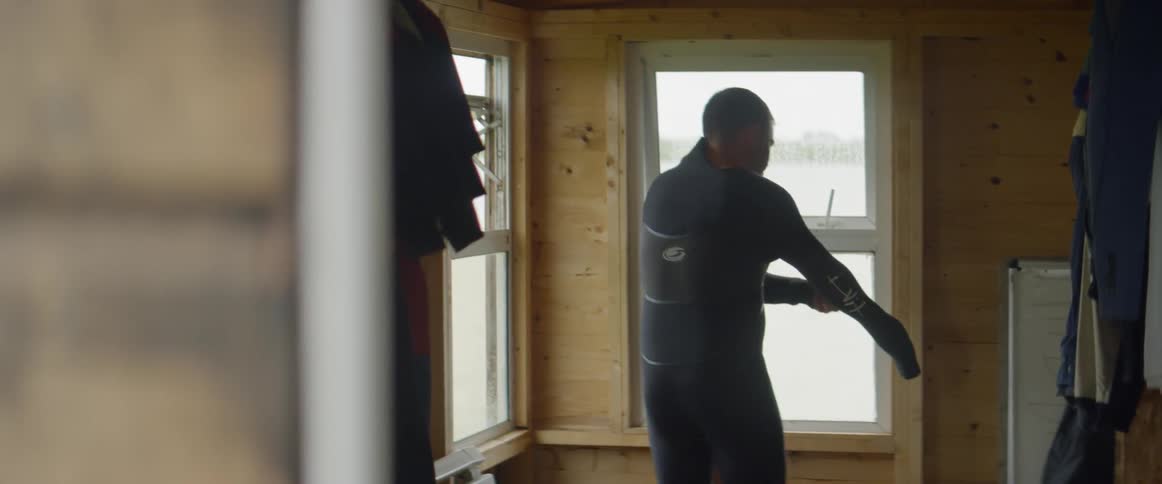A man puts on a wet suit