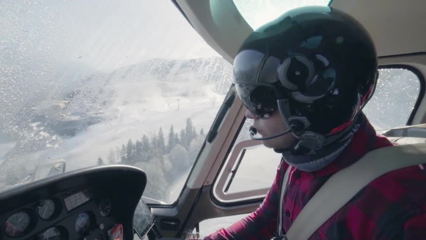 Person in helmet pilots a helicopter