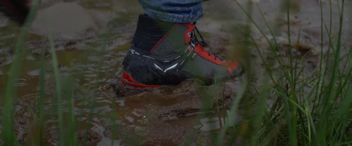 A person walks through the mud