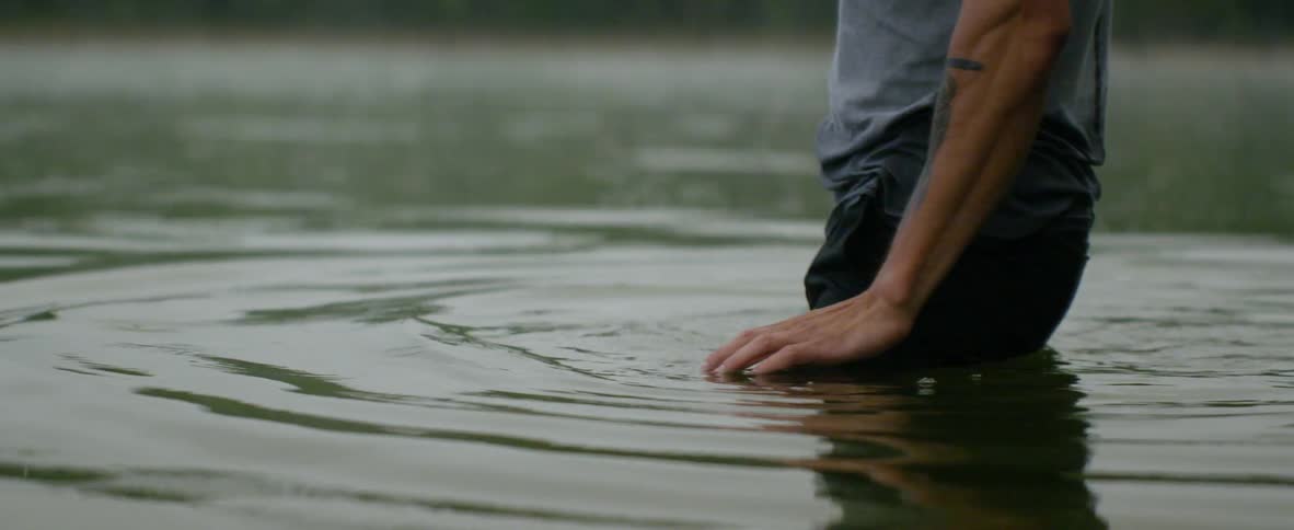 A man walks into a body of water