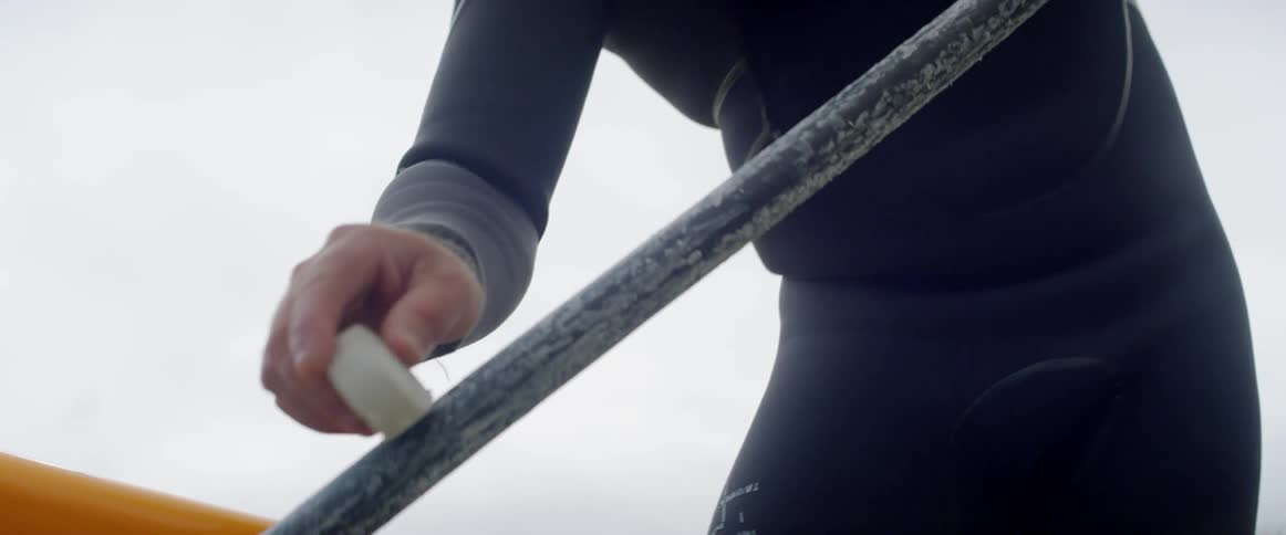 A man is polishing his ore for his boat or surfboard