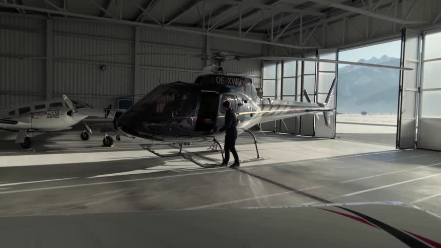 A pilot enters the cockpit of a helicopter