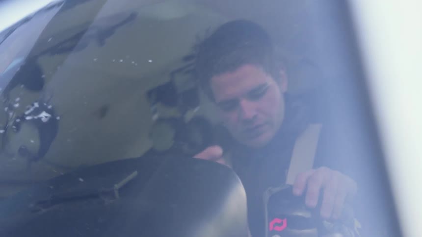 A helicopter pilot puts on his helmet