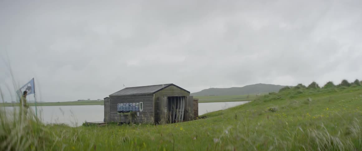 A shed sits near a body of water