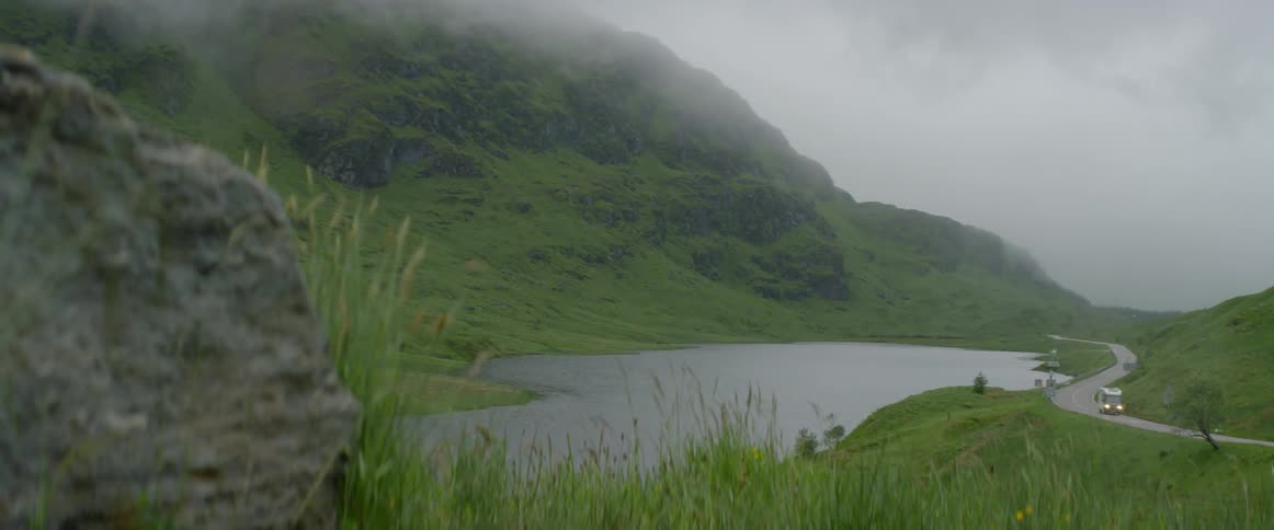 Mountains near a river and road on a cloudy day