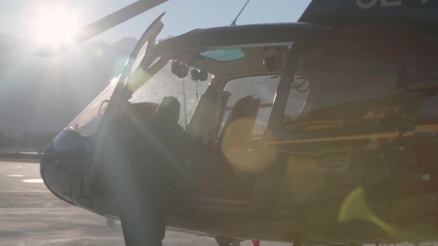 A man stands in front of an open helicopter