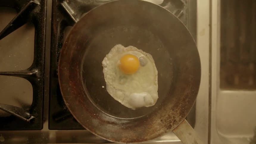 An egg is dropped into a hot pan