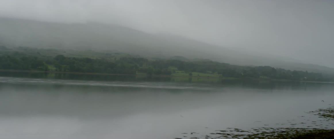 Mist hovers over a mountain lake