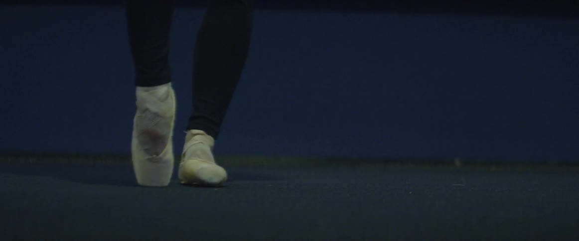 A ballet dancer is practicing standing on their toes