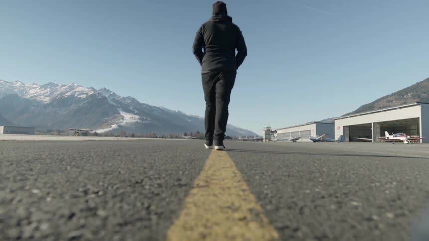 A man walks on an airport runway
