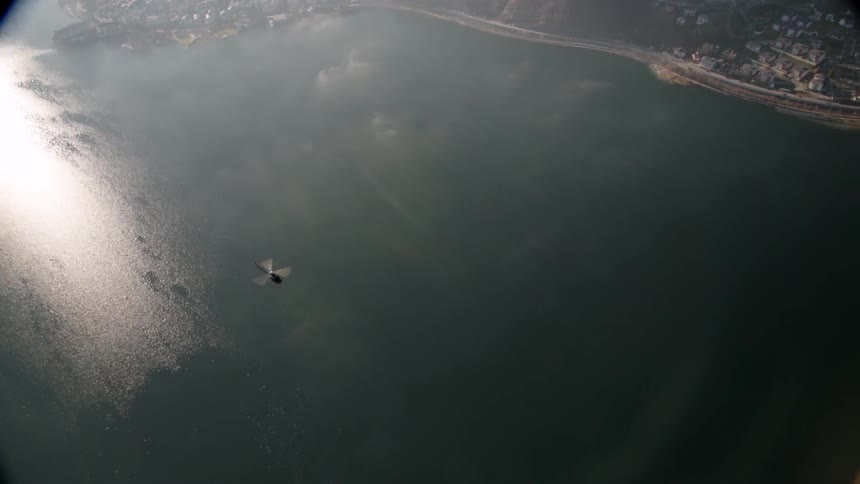A helicopter flies over a lake
