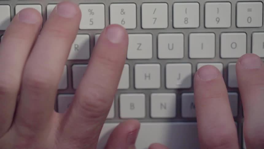 Hands type on a keyboard