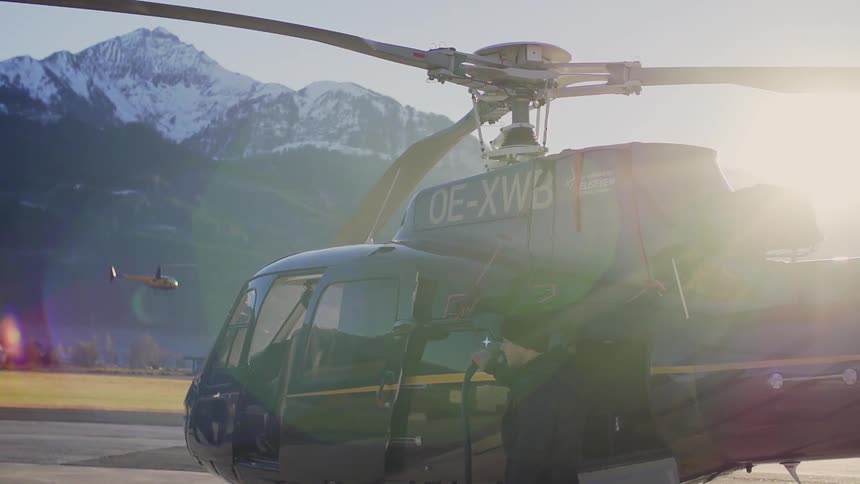 Helicopter grounded near a snowy mountain at an airport