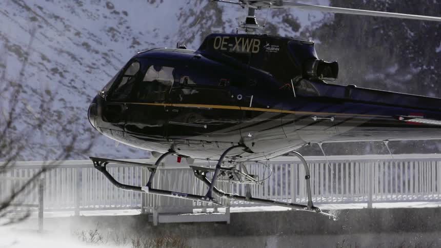 A helicopter is hovering low above a lake