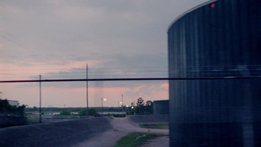Large round silos are filmed from a passing car