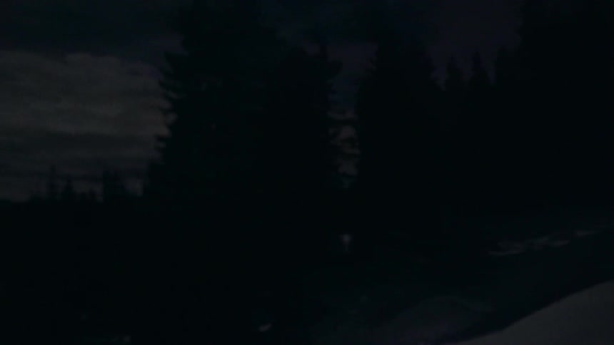 A man is trekking on a mountain covered with snow at night