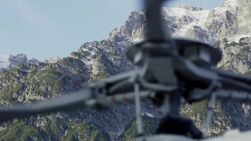 Helicopter rotor spinning in front of large mountains