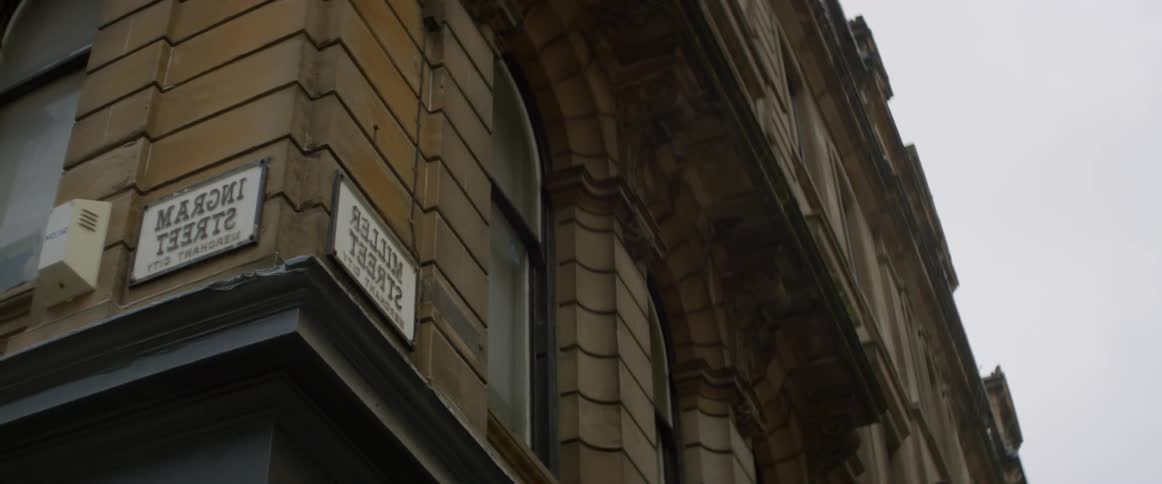 A sign is mounted on each side of a building