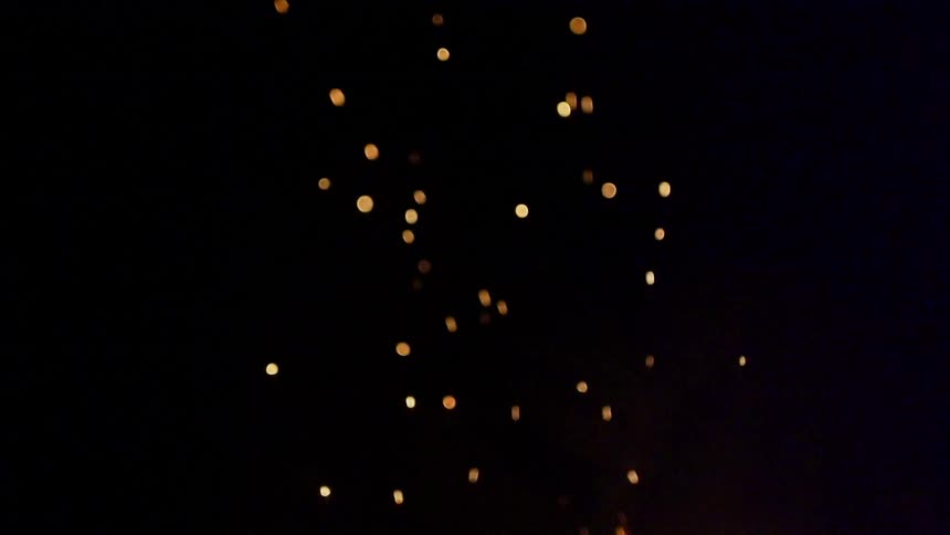 Embers float into the dark night sky