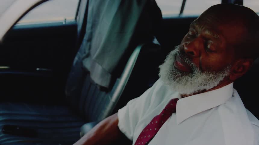 Man sits in driver's seat while thinking