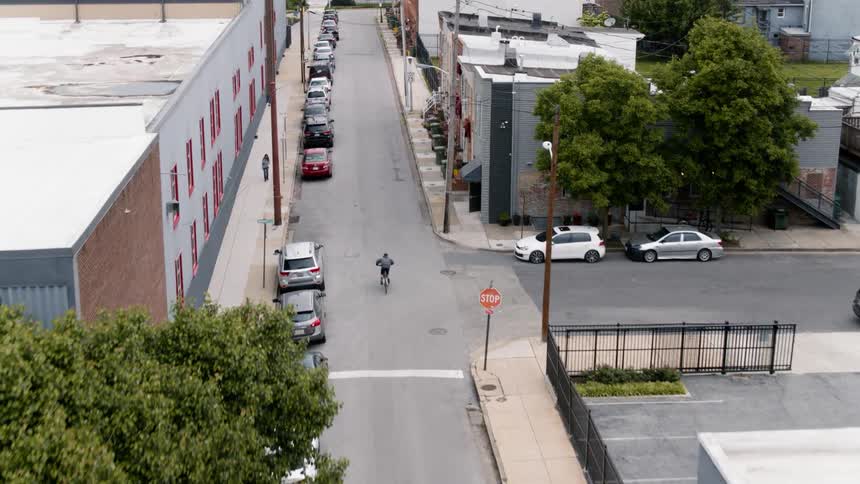 A young man rides a bicycle down the street