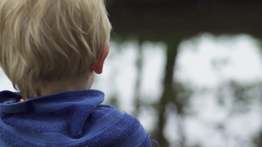 Child gazes at a lake